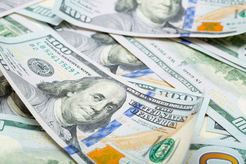 One hundred dollar bills are creatively laid out. Beautiful original cash flow. One hundred bucks as a background on a long banner in high resolution.